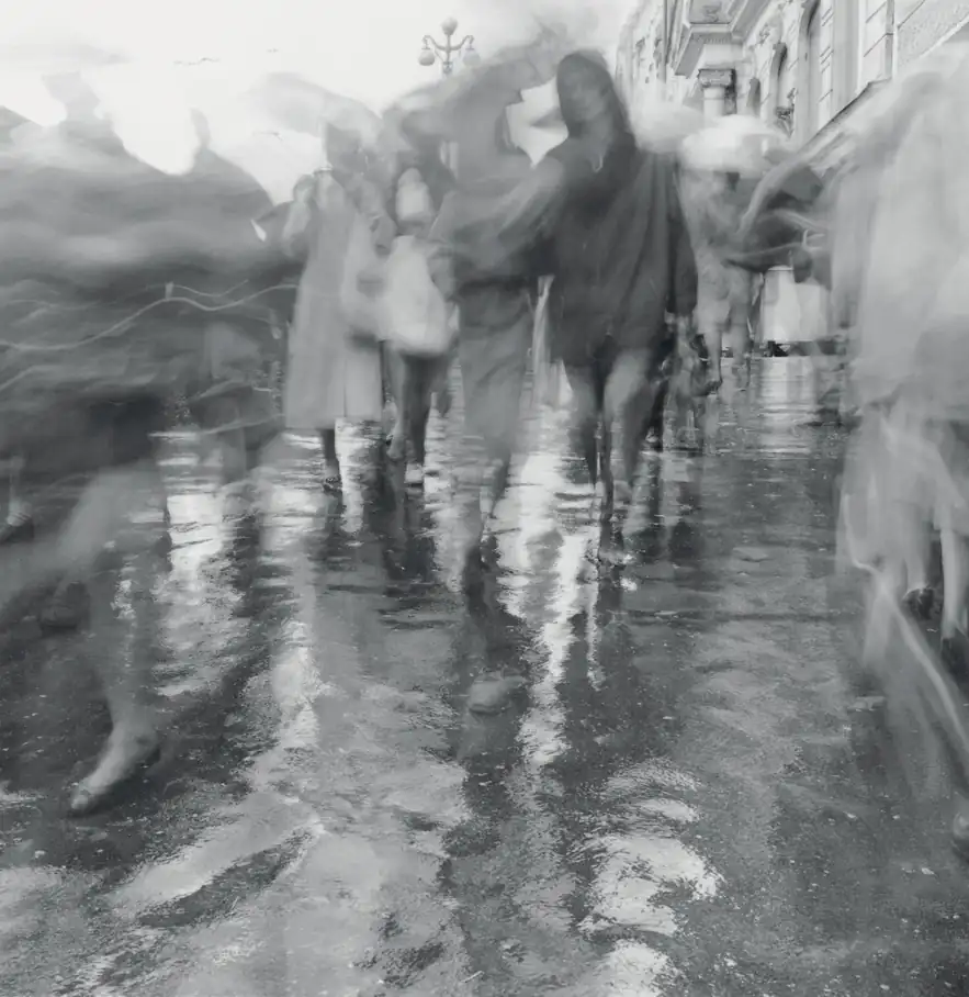 Umbrellas and blurred pedestrians move across rain-soaked Nevsky Prospect in Saint Petersburg.