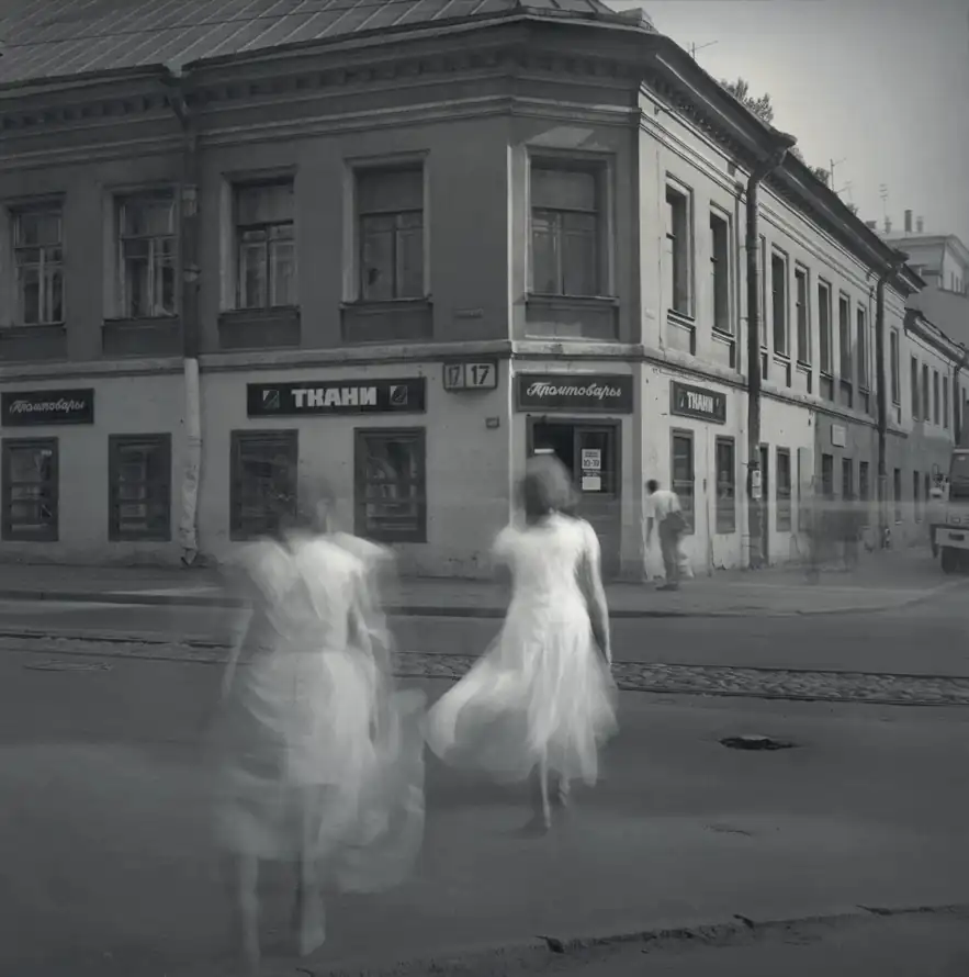 Two women in white dresses blur as they cross an empty Saint Petersburg street.