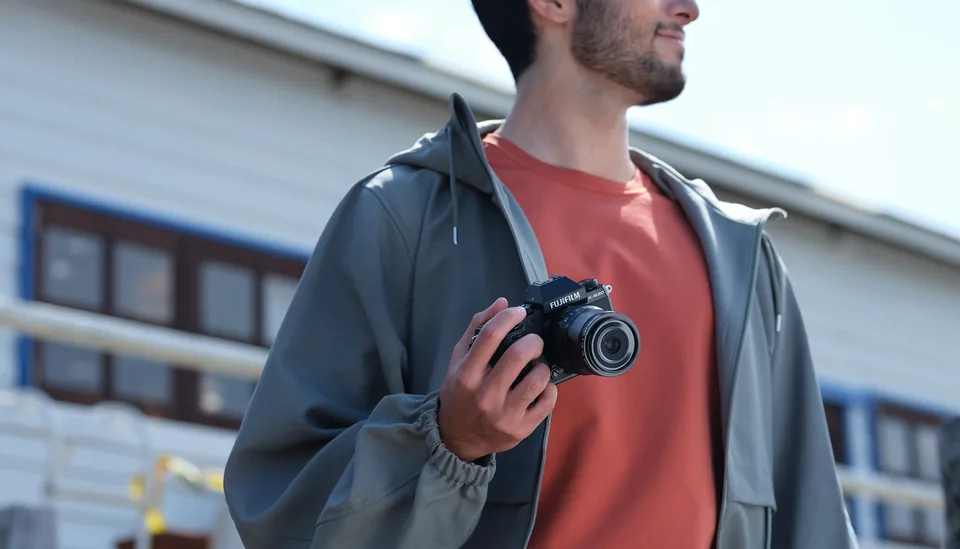 Photographer holding a compact Fujifilm X-S20 camera